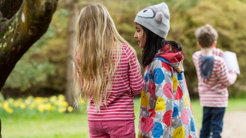 Children walking in a spring garden with daffodils in the background